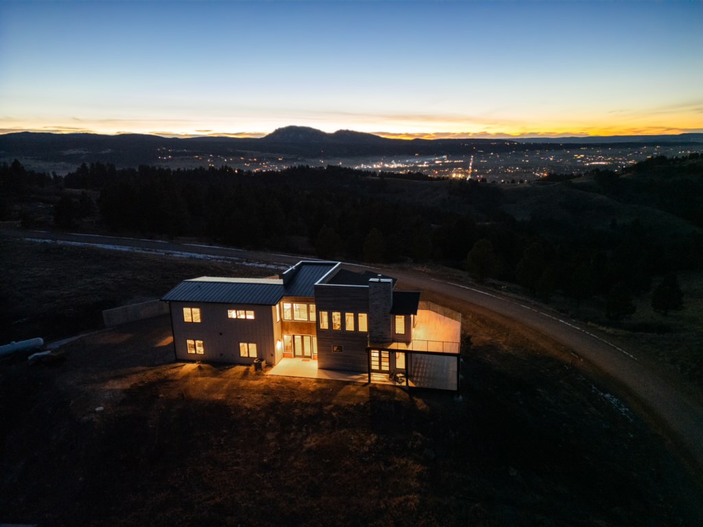 A night aerial view shows 2111 Vantage Circle glowing above the Spearfish valley