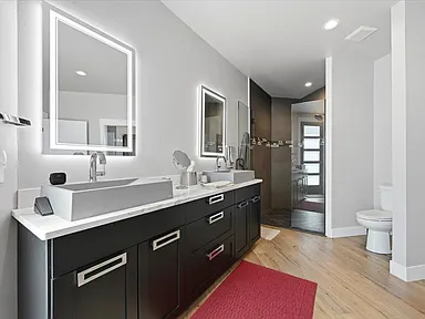 Primary bath — double vanity, lit mirrors