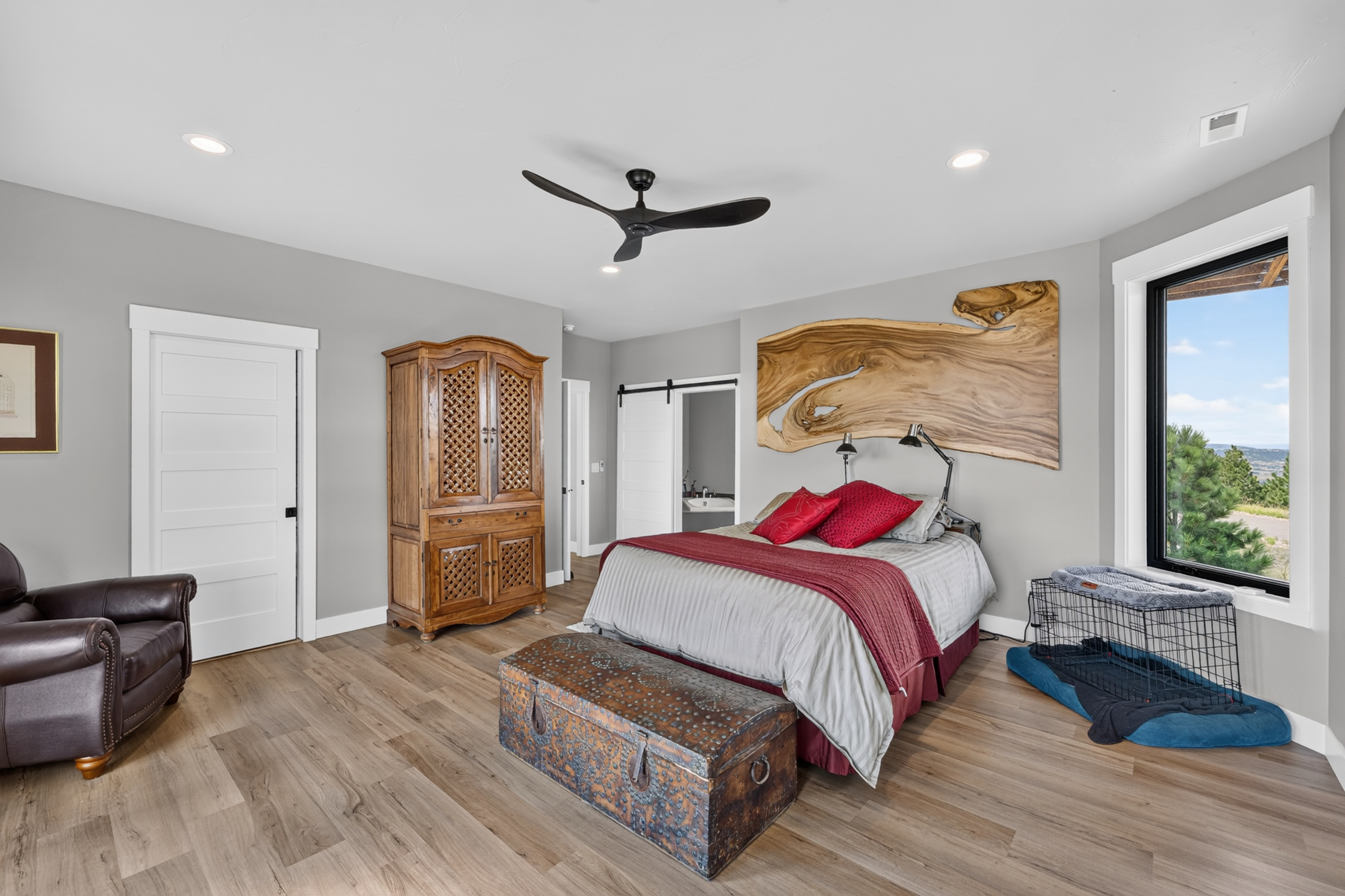 A bedroom features a large live-edge wood slab mounted above the bed as a headboard